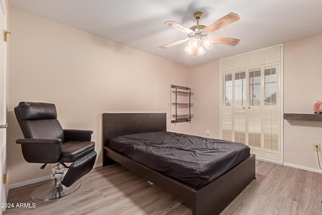 bedroom featuring ceiling fan, light hardwood / wood-style floors, and a closet