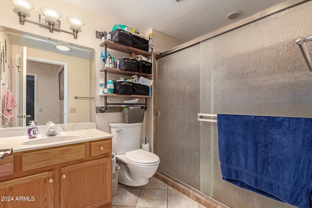 bathroom featuring walk in shower, vanity, a textured ceiling, tile patterned flooring, and toilet