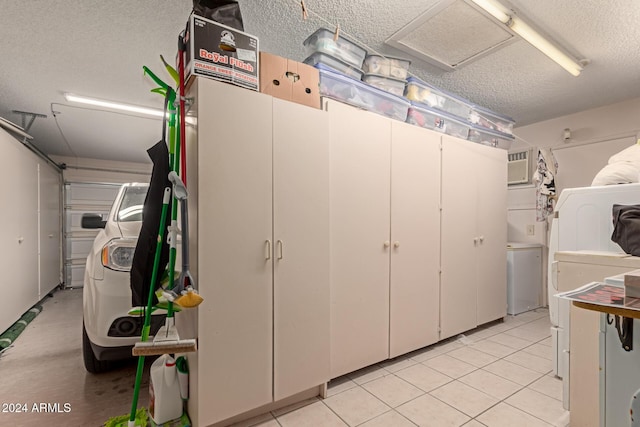 garage with a wall mounted AC and washer and dryer