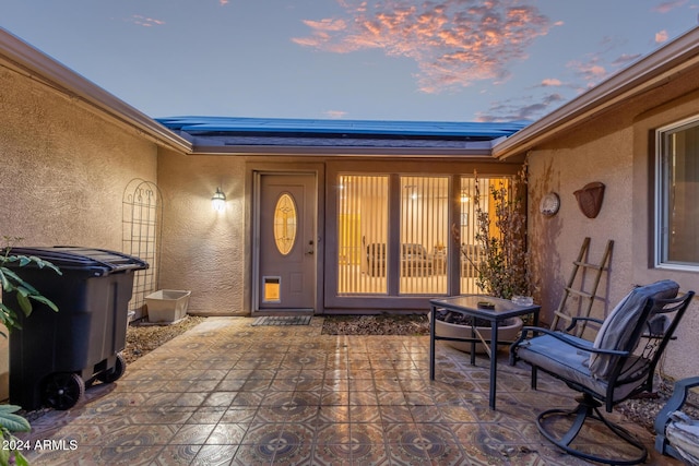 exterior entry at dusk with a patio area