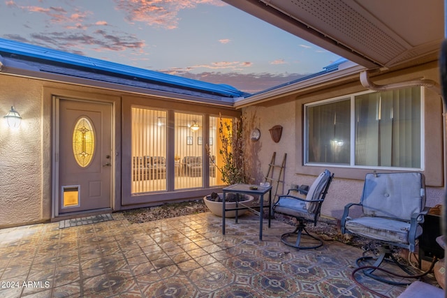 exterior entry at dusk with a patio area