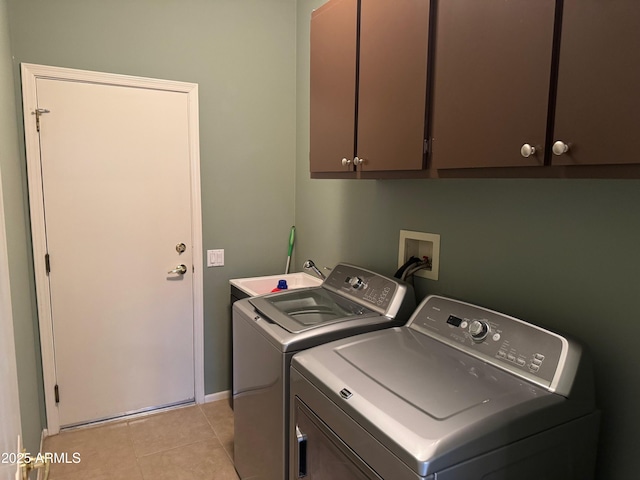 washroom featuring washing machine and clothes dryer, baseboards, light tile patterned floors, and cabinet space