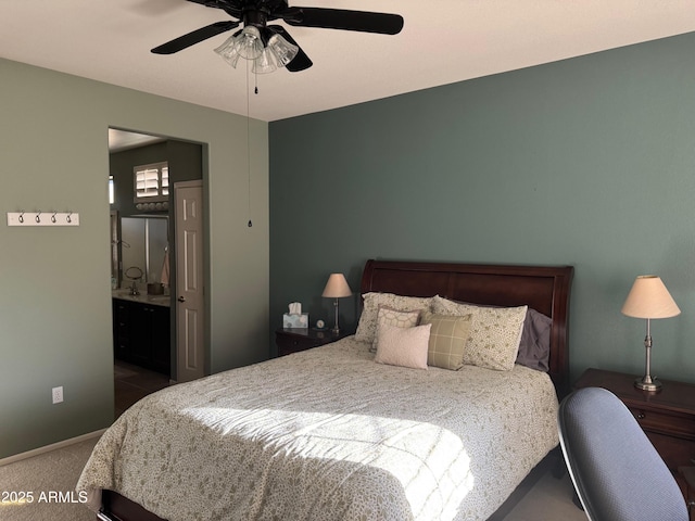 carpeted bedroom featuring ceiling fan and ensuite bath
