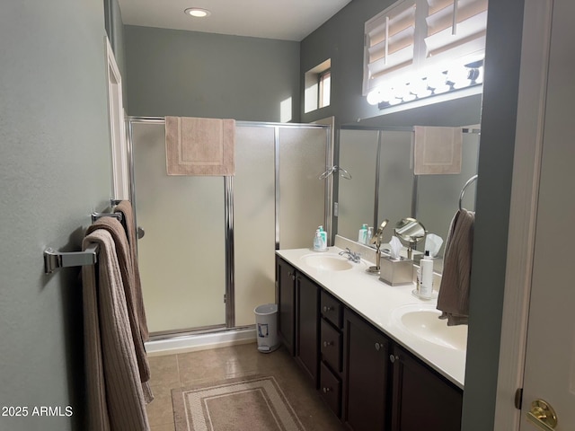 full bathroom with tile patterned floors, a sink, double vanity, and a stall shower