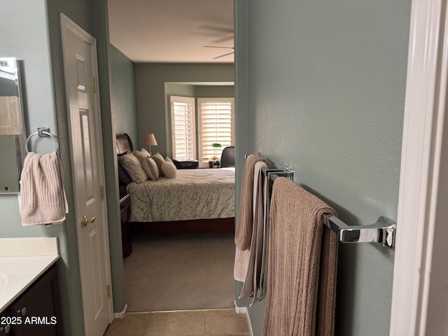 bedroom with light tile patterned flooring, baseboards, and light colored carpet