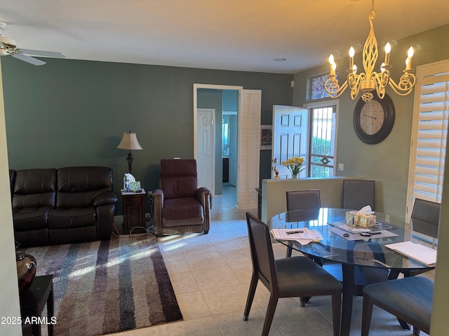 dining space featuring light tile patterned flooring and ceiling fan with notable chandelier