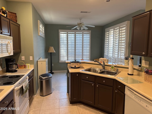kitchen featuring dark brown cabinets, ceiling fan, a sink, and white appliances