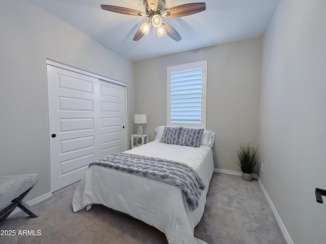 bedroom with baseboards, a closet, a ceiling fan, and light colored carpet