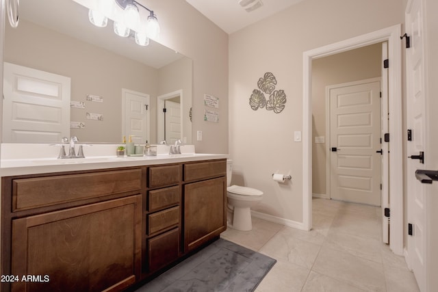 bathroom with double vanity, baseboards, visible vents, toilet, and a sink