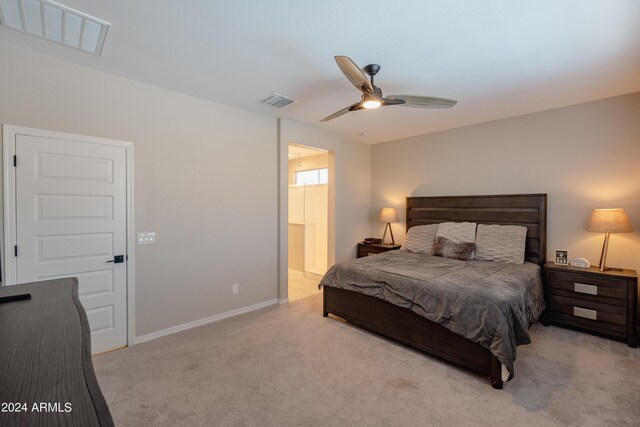 carpeted bedroom featuring ceiling fan, ensuite bathroom, visible vents, and baseboards