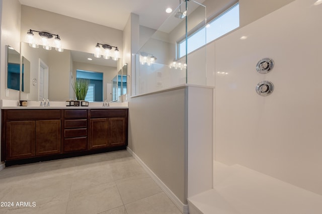 full bath with tile patterned flooring, double vanity, a sink, and a walk in shower