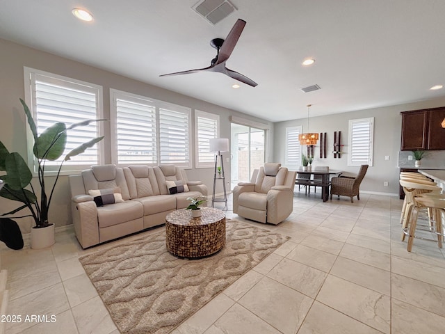 living room featuring a ceiling fan, recessed lighting, visible vents, and baseboards