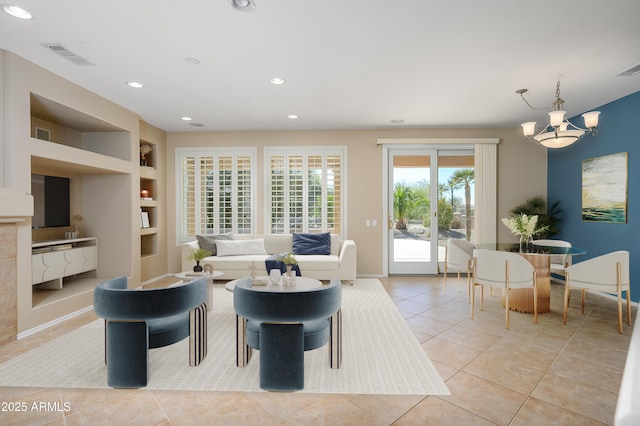 living room featuring light tile patterned floors, built in features, and an inviting chandelier