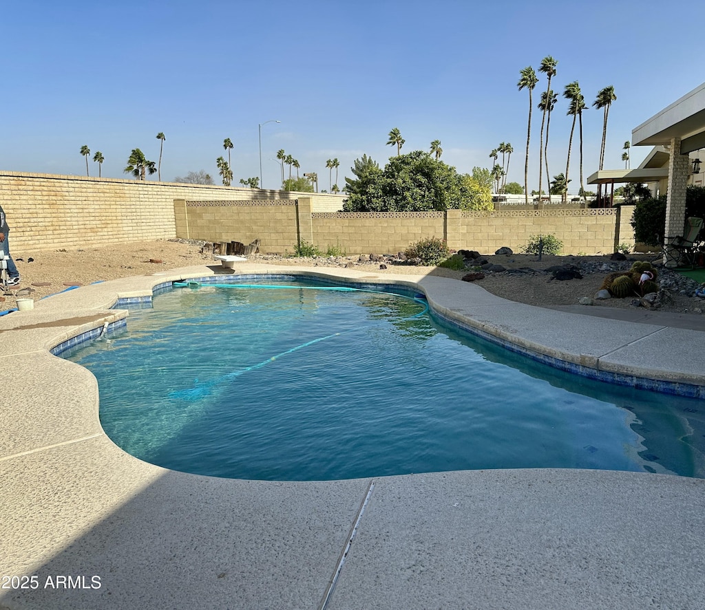 view of swimming pool featuring a diving board, a fenced in pool, and a fenced backyard