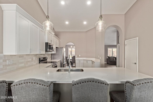 821 E Chicago St, Chandler, AZ 85225 - kitchen with stainless steel appliances, arched walkways, light stone counters, and a sink