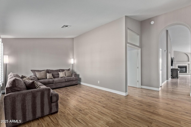 821 E Chicago St, Chandler, AZ 85225 - living area with visible vents, wood finished floors, a fireplace, baseboards, and arched walkways