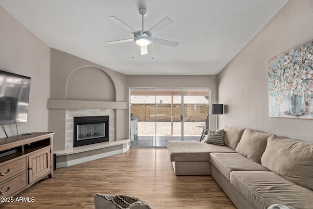 821 E Chicago St, Chandler, AZ 85225 - living room featuring a textured ceiling, ceiling fan, a tiled fireplace, and wood finished floors