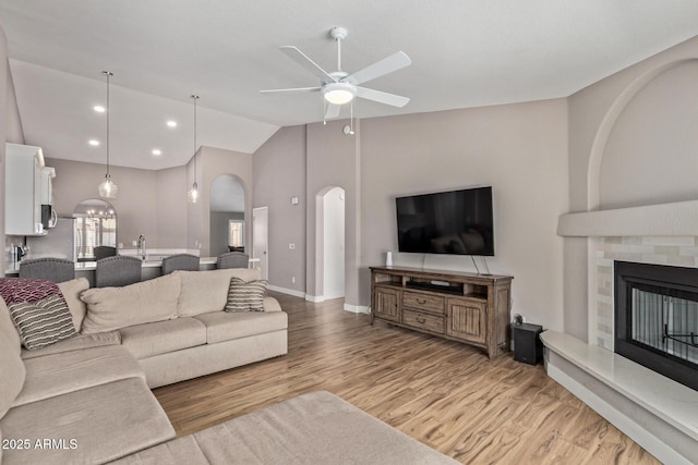 821 E Chicago St, Chandler, AZ 85225 - living area with ceiling fan, light wood-style floors, arched walkways, a fireplace with raised hearth, and baseboards