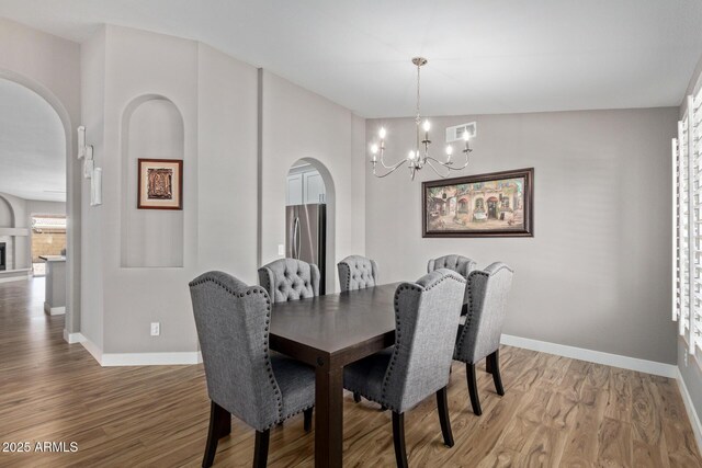 821 E Chicago St, Chandler, AZ 85225 - dining space featuring arched walkways, baseboards, a notable chandelier, and light wood-style floors