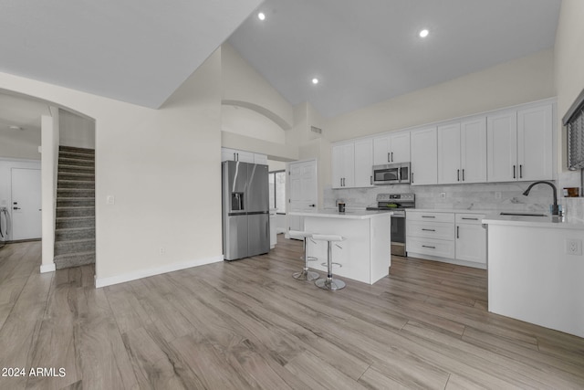 kitchen with appliances with stainless steel finishes, a center island, sink, and white cabinets