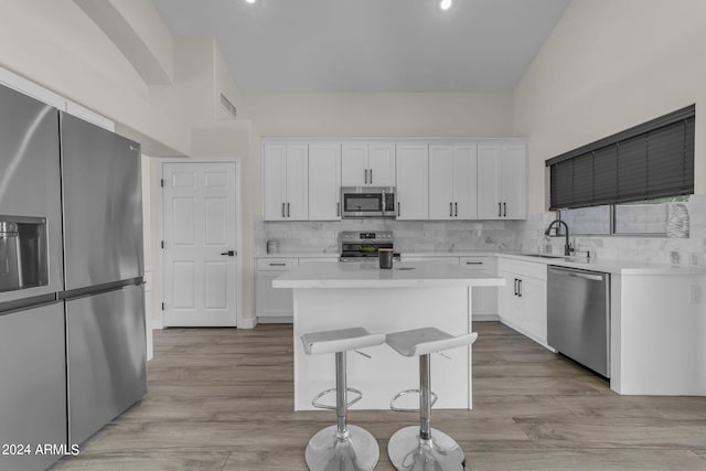 kitchen featuring sink, stainless steel appliances, a center island, and white cabinets