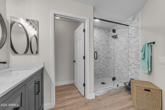 bathroom featuring a shower with door, vanity, and wood-type flooring