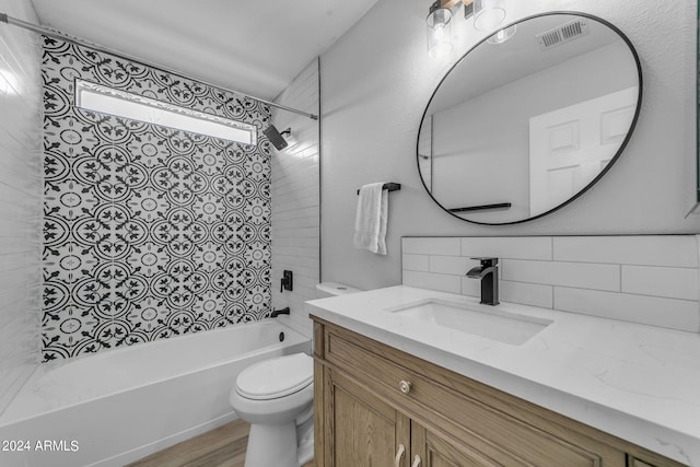 full bathroom featuring toilet, tasteful backsplash, tiled shower / bath, vanity, and hardwood / wood-style flooring