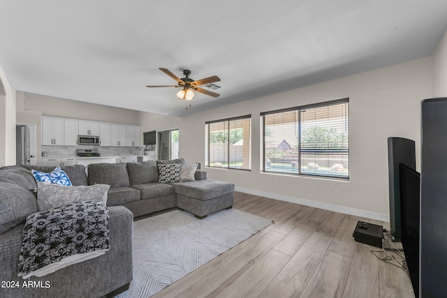 living room with ceiling fan and light wood-type flooring