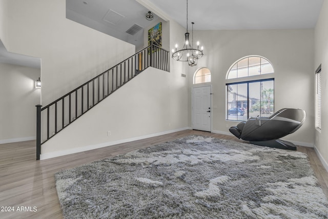 foyer with hardwood / wood-style floors, a notable chandelier, and high vaulted ceiling