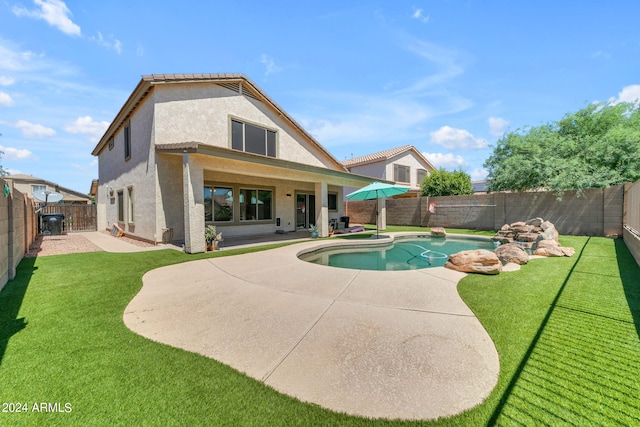 back of property featuring a fenced in pool, a yard, and a patio area