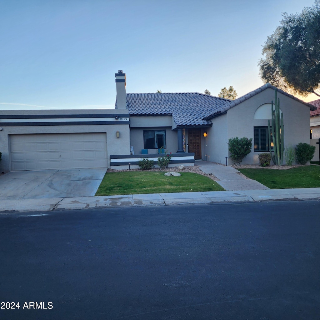 view of front of property featuring a garage and a front lawn