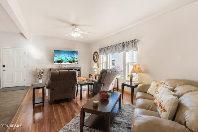 living room with ceiling fan, beamed ceiling, and dark wood-type flooring