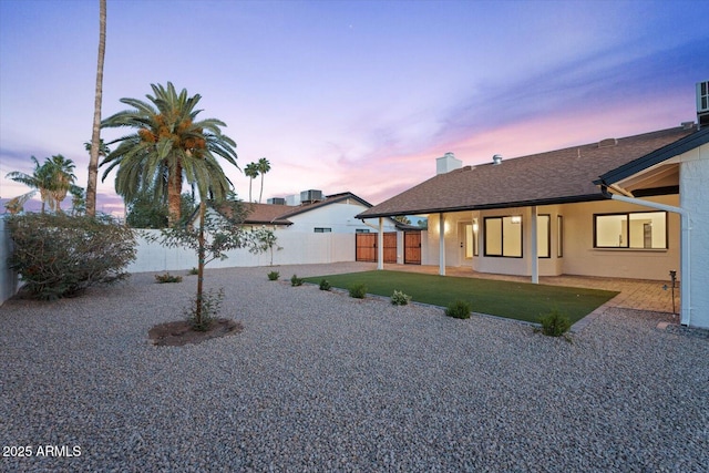 6228 E Blanche Dr, Scottsdale, AZ 85254 - back of property at dusk with a patio area, a chimney, and roof with shingles