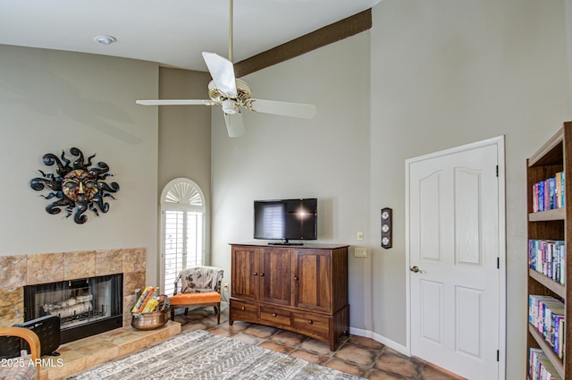 living room with a tile fireplace, ceiling fan, and high vaulted ceiling