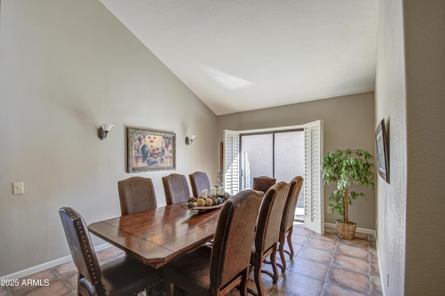 tiled dining space featuring vaulted ceiling