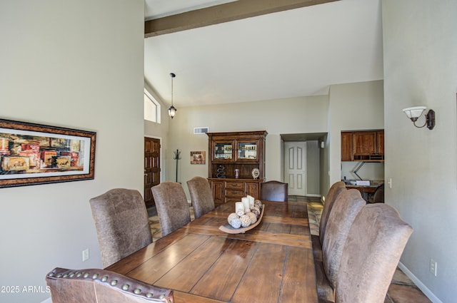 dining space with beamed ceiling and high vaulted ceiling