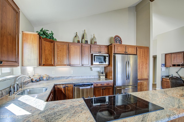 kitchen featuring sink, high vaulted ceiling, appliances with stainless steel finishes, kitchen peninsula, and light stone countertops