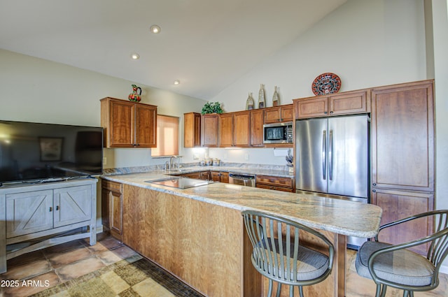 kitchen featuring sink, high vaulted ceiling, kitchen peninsula, stainless steel appliances, and light stone countertops