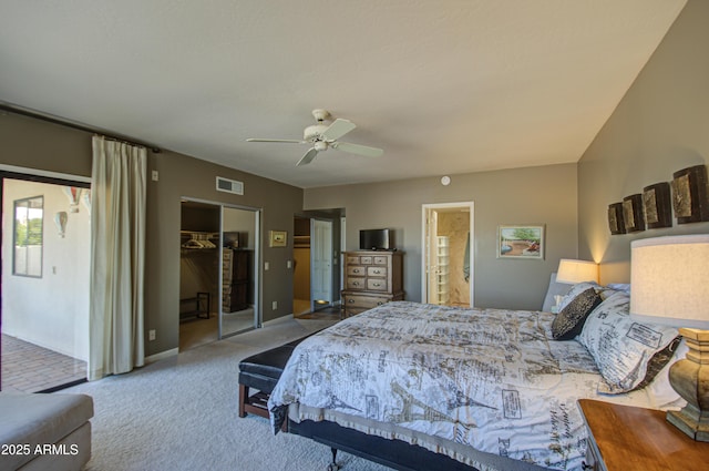 bedroom featuring ceiling fan, ensuite bathroom, carpet, a walk in closet, and a closet