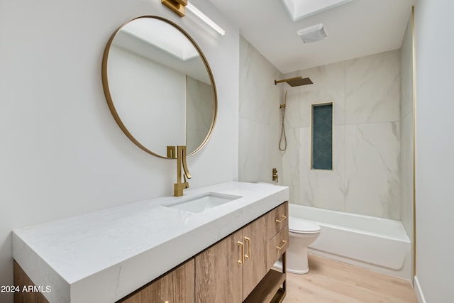 full bathroom featuring tiled shower / bath combo, hardwood / wood-style floors, vanity, and toilet