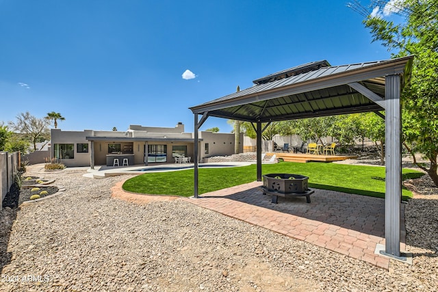 exterior space with a fire pit, a swimming pool, a gazebo, and a patio area