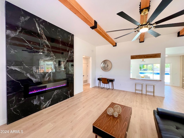 living room featuring light hardwood / wood-style flooring, ceiling fan, and beam ceiling