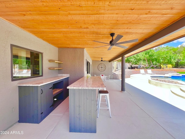 view of patio / terrace featuring a swimming pool, ceiling fan, and an outdoor bar