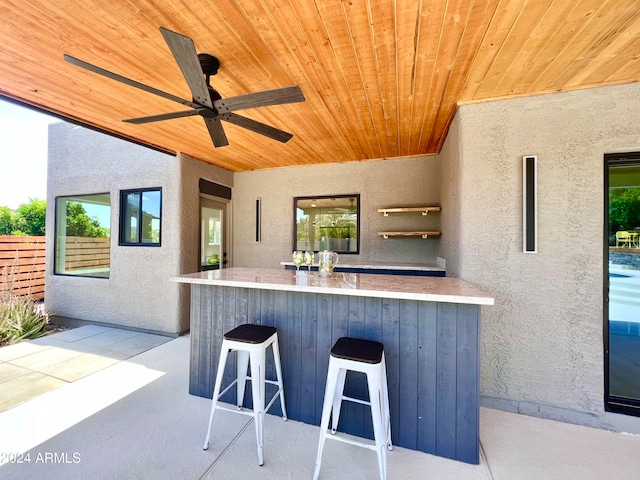 view of terrace featuring ceiling fan and a bar