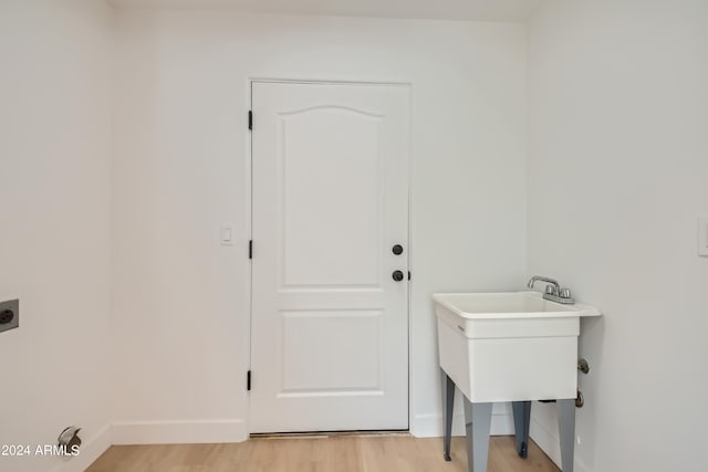 clothes washing area with light hardwood / wood-style flooring and electric dryer hookup