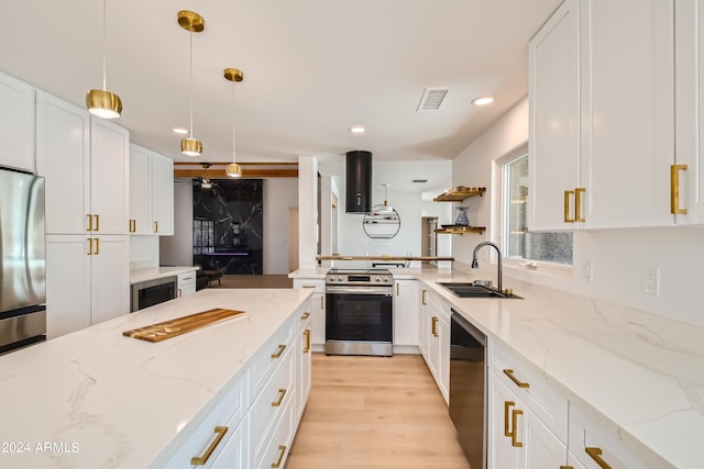 kitchen featuring white cabinets, sink, light hardwood / wood-style floors, stainless steel appliances, and pendant lighting