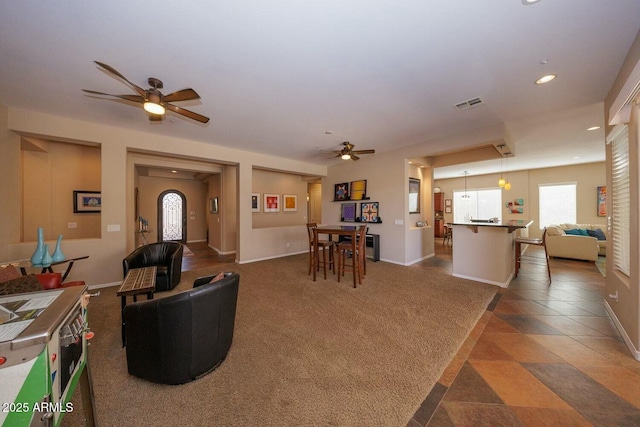 carpeted living room with ceiling fan