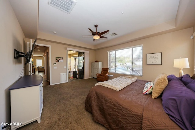 carpeted bedroom featuring a raised ceiling and ceiling fan