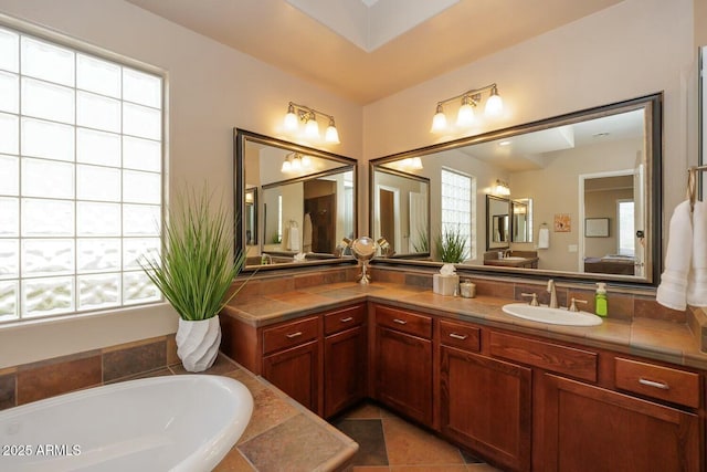 bathroom featuring vanity, tiled bath, and tile patterned flooring