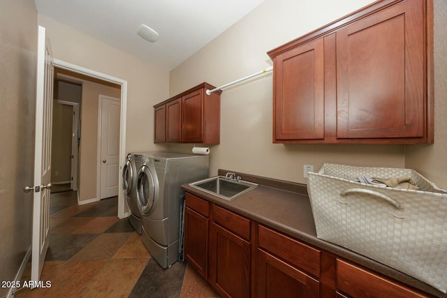 clothes washing area featuring cabinets, sink, and washer and dryer